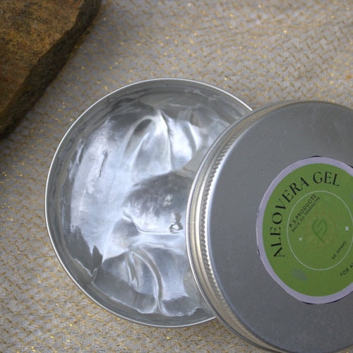 Metal tin with aloe vera gel on a stone surface with lime slices.
