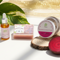 Collection of natural skincare products on a white surface with green leaves in the background