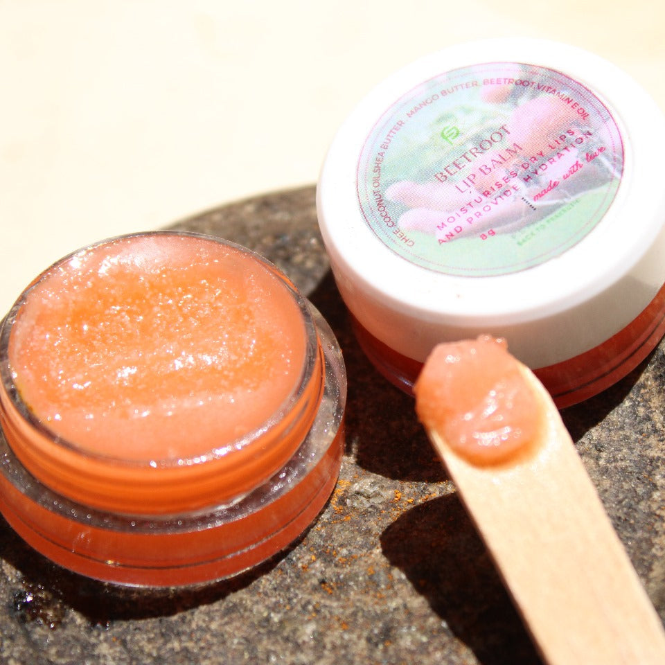 Lip balm container with a stick of lip balm on a textured surface