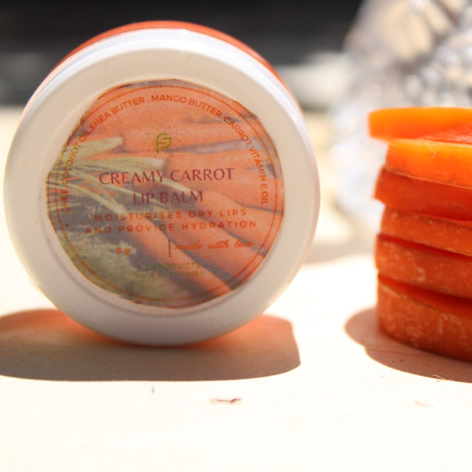 Jar of creamy carrot lip balm and sliced carrots on a white background