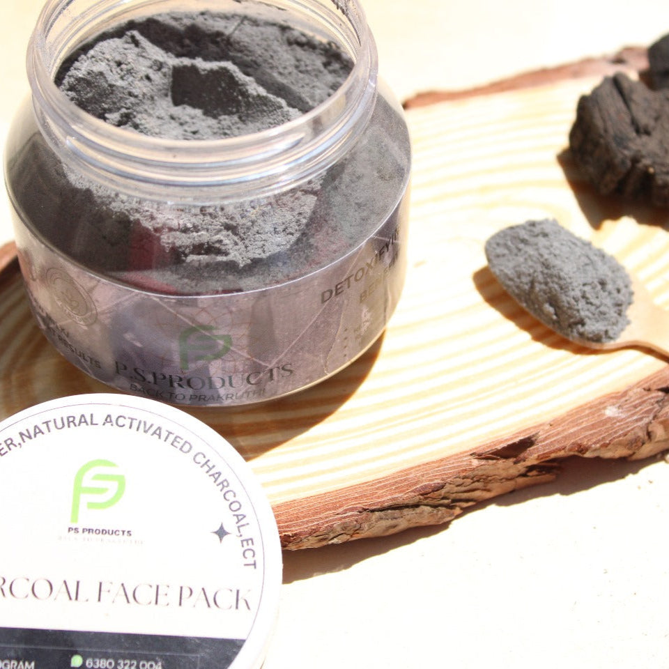 Jar of charcoal face pack with activated charcoal on a wooden board