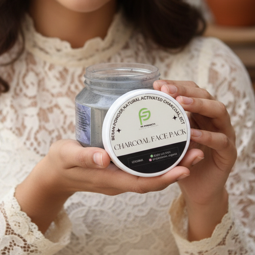 Woman holding a jar of charcoal face pack with a blurred indoor background