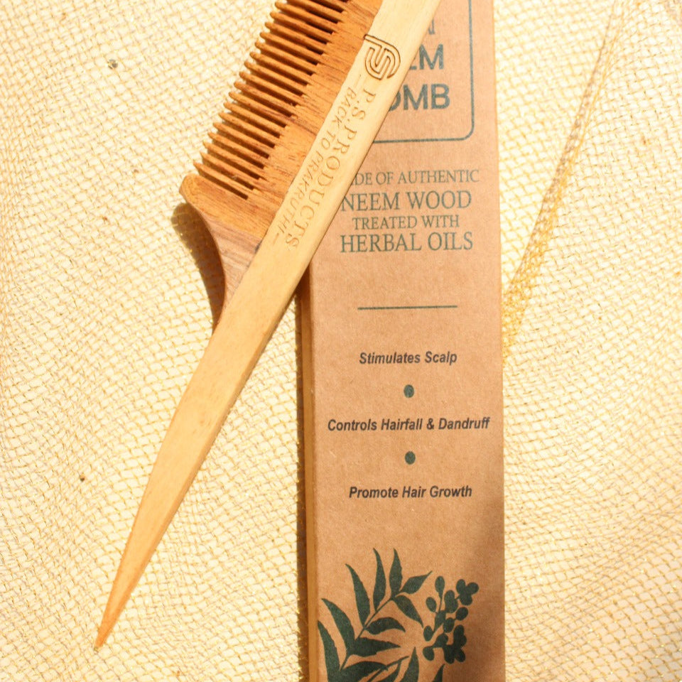Wooden comb and packaging on a textured beige background