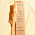 Neem comb and packaging on a textured beige background
